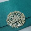 Large flower rhinestone brooch for wedding embellishment shown on a silk envelope