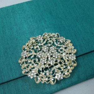 Large flower rhinestone brooch for wedding embellishment shown on a silk envelope