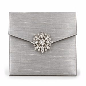 Luxury silver Thai Dupioni silk wedding invitation envelope with rhinestone crystal brooch and magnetic closure.