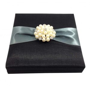 Embellished black faux silk wedding invitation box with large pearl brooch