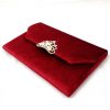 Side view of velvet envelope with pearl crown brooch