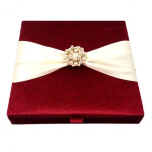 red velvet invitation box with pearl brooch embellishment