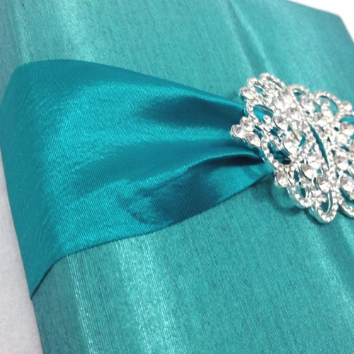 Detail view of our luxury silk wedding invitation box featuring rhinestone crown brooches