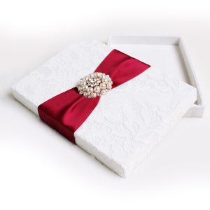 white lace wedding box with red ribbon and pearl brooch