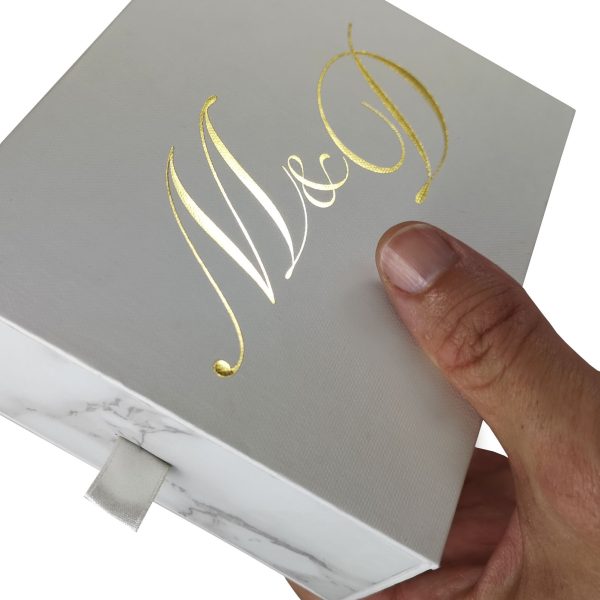 Marble drawer box with ribbon pull and gold foil stamped logo