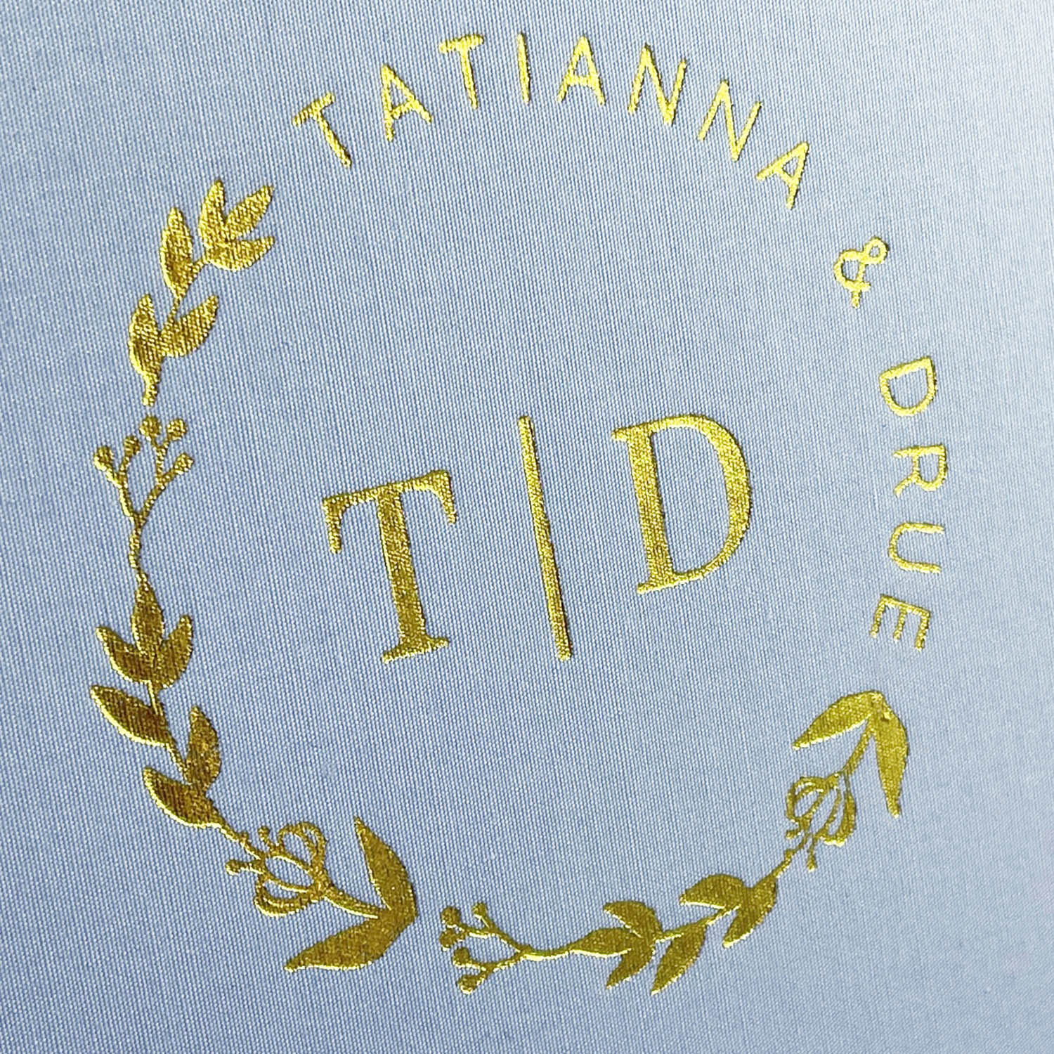 Gold foil stamped crest on linen fabric
